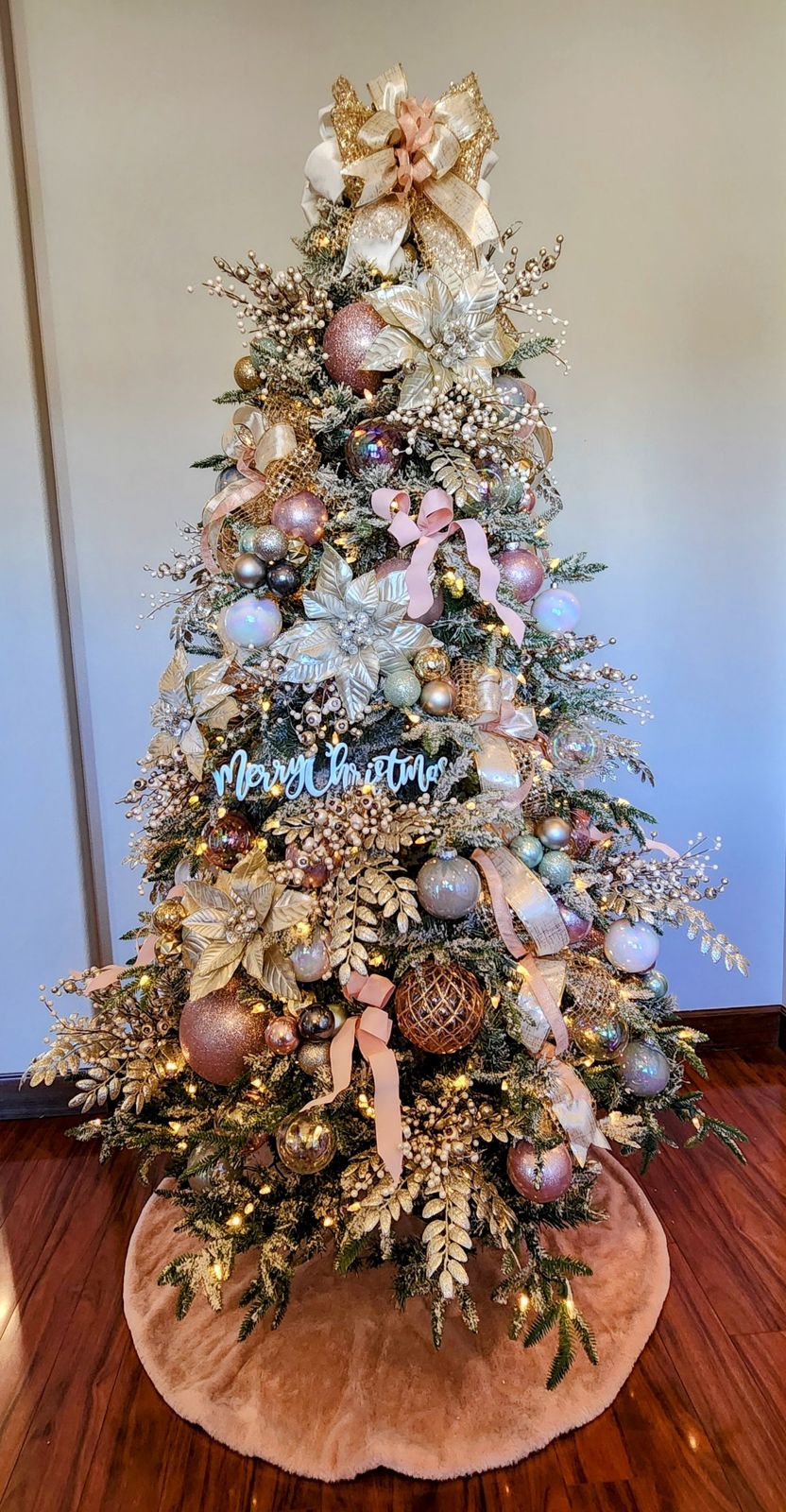 Flocked tree in blush pink, champagne gold and iridescent ornaments with gold poinsettias